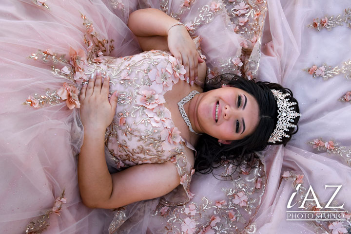 Sesión de Fotos de Quinceañera con uñas decoradas: Guía Definitiva en Mesa, Arizona 3 Ideas de Unas para Quinceaneras Modernas en Tendencias 2024 2025 3 Ideas de uñas para quinceañeras modernas en tendencias 2024 2025 una quinceañera recostada en su vestido sonriendo con sus uñas decoradas